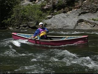 Surfing a canoe in whitewater